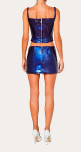 Person wearing a shiny blue outfit with a top and skirt on a white background